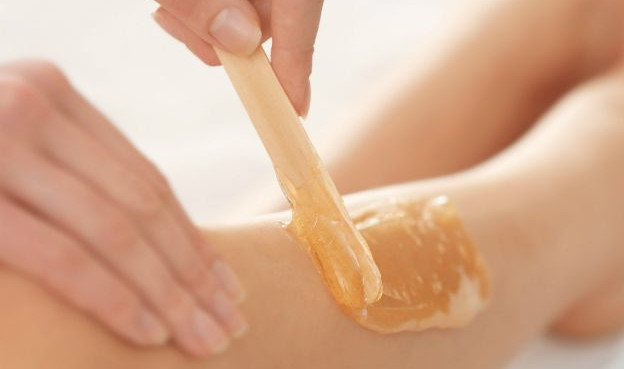 Depilação com cera nas pernas realizada em uma mulher